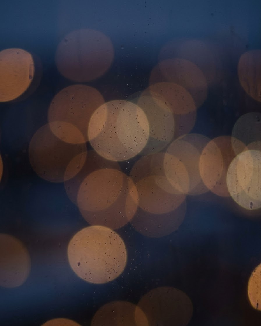 Blue-hour city lights blurred through glass