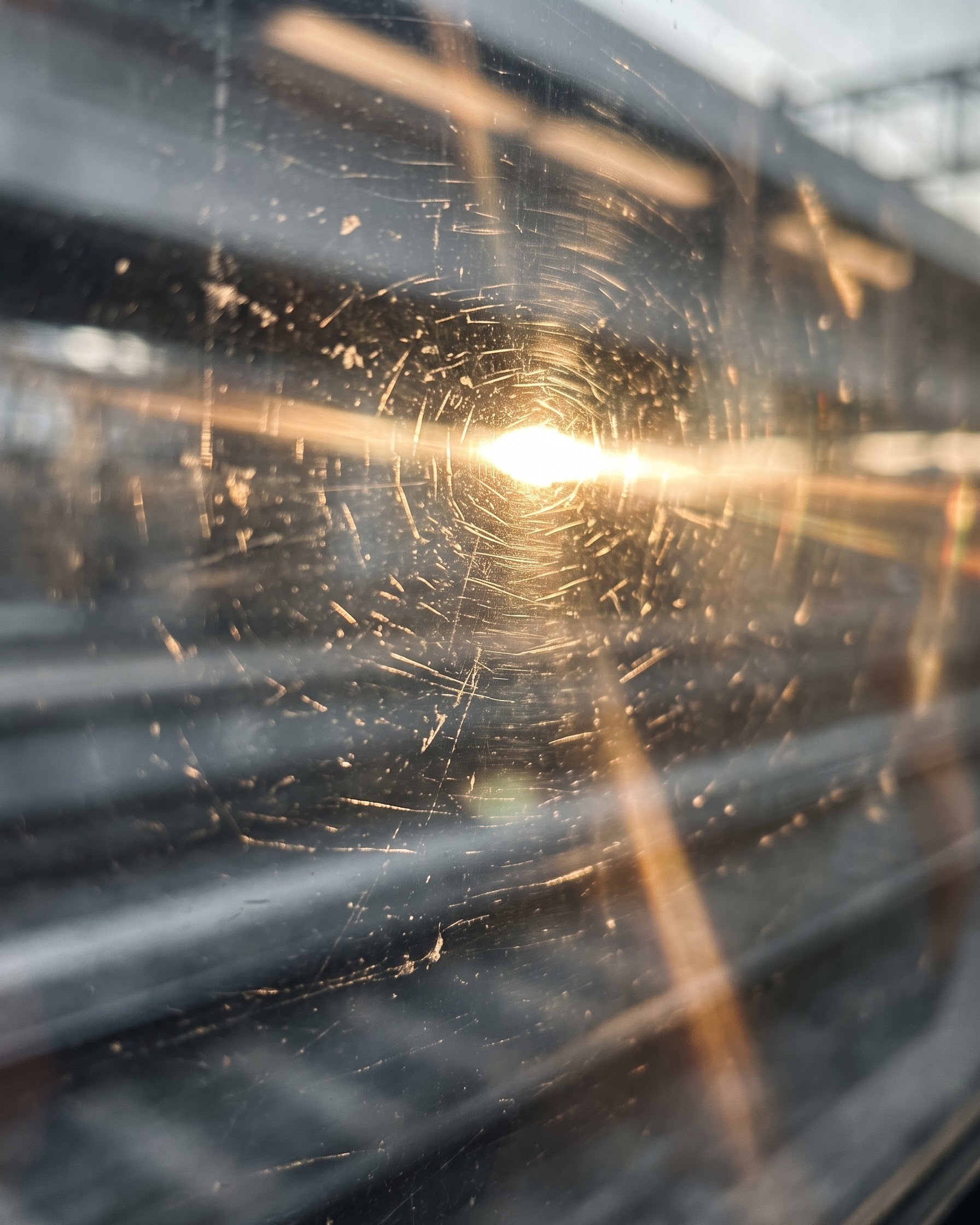 A hard streak of morning sun through a train window
